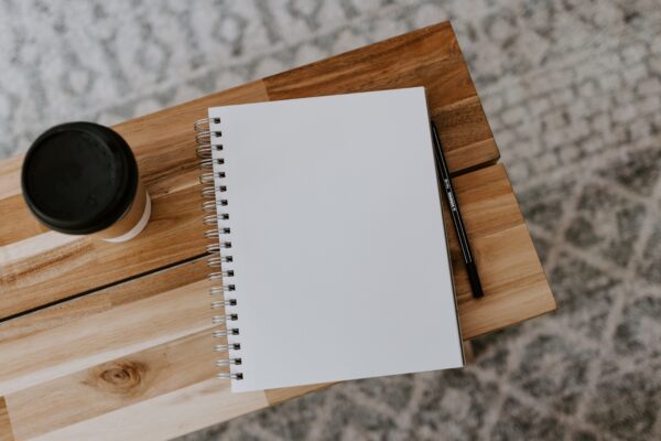 A blank piece of paper with a cup of coffee beside it.