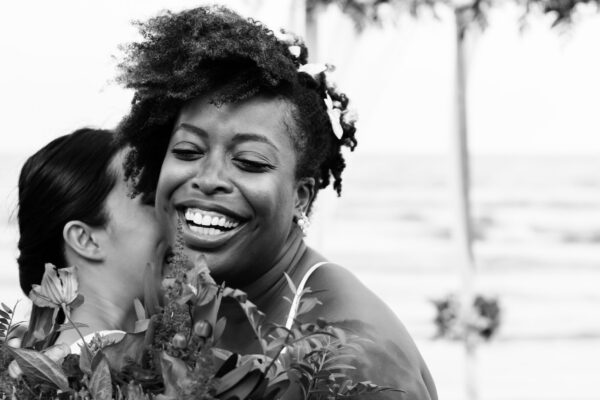 a woman hugs the bride after delivering a maid of honour speech for her younger sister