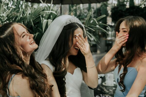A maid of honour and the bride laugh.